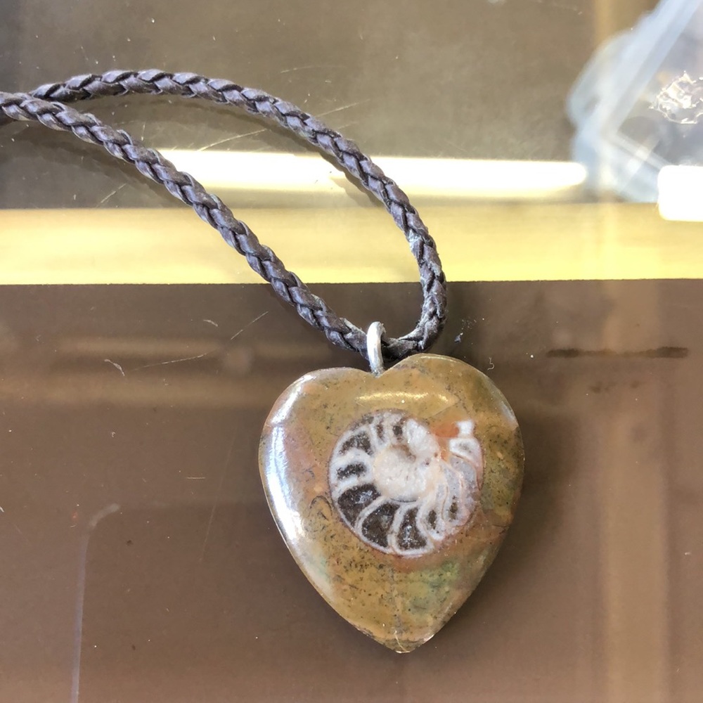 Hand painted heart shaped pendant paired with a braided faux leather cord